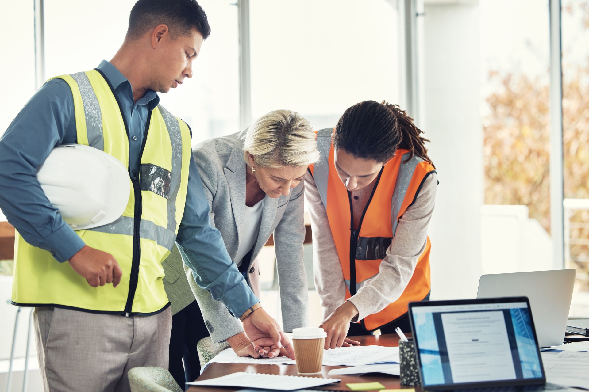 Ingeniería, trabajo en equipo y reunión con personas en oficina para construcción, diseño y edificación. Colaboración, revisión y planificación con grupo en estudio de arquitectura para la gestión de proyectos y objetivos